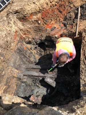 Archäologen legen eine alte hölzerne Wasserleitung frei