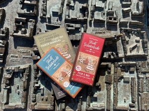 Drei Tafeln der neuen Fair Trade Stadtschokolade liegen auf der Miniaturansicht von Greifswald