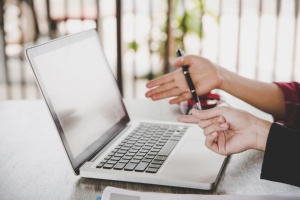Symbolbild Online-Dienst © jcomp auf Freepik.com Zwei Hände zeigen auf einen Laptop-Bildschirm