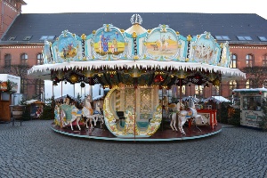 Das nostalgische Karussell mit Kutschen und hölzernen Pferdchen auf dem Greifswalder Weihnachtsmarkt