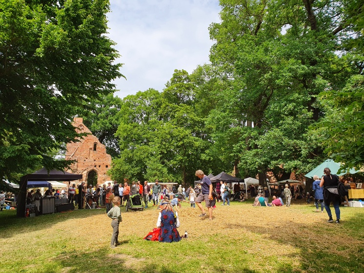 Strohschlacht mit Blick auf das Westportal der Klosterruine - Eldenaer Klostermarkt 2022 - © UHGW-Kultur Strohschlacht mit Blick auf das Westportal der Klosterruine - Eldenaer Klostermarkt 2022
