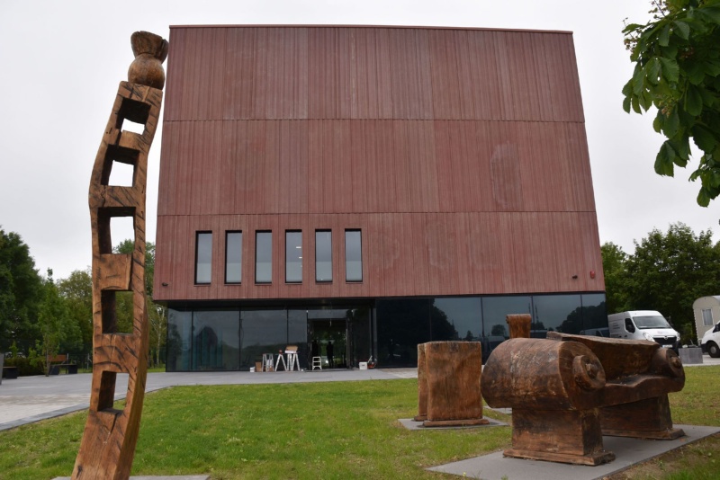 Blick auf das neu gebaute Stadtarchiv in Greifswald mit Holzskulpturen im Vordergrund