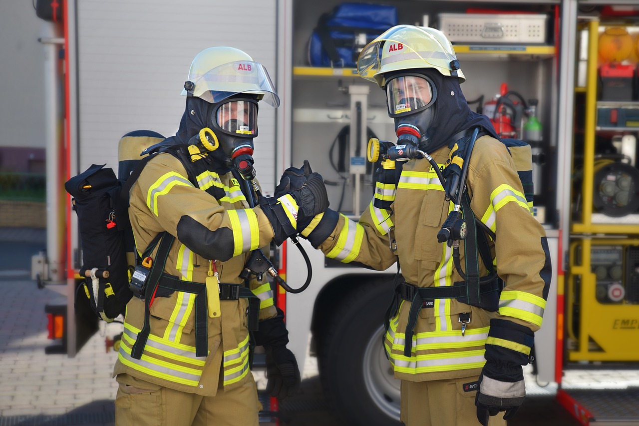 Zwei Feuerwehrleute reichen sich die Hand als Team