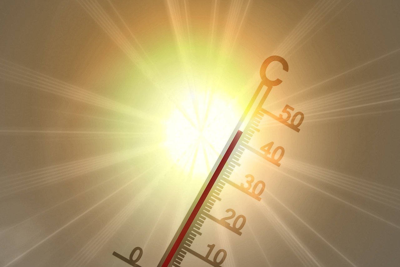 Thermometer mit Sonne im Hintergrund