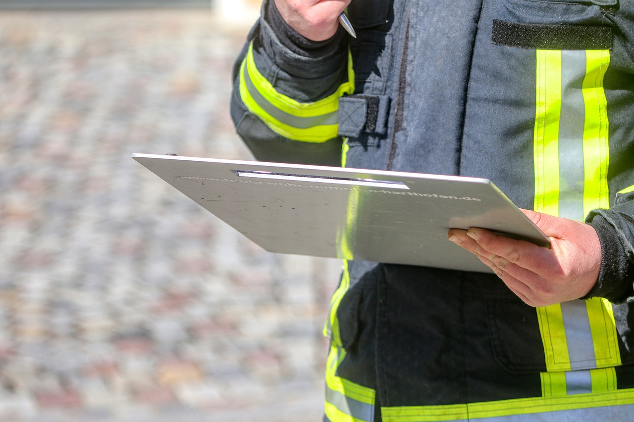 Feuerwehrmann hält Klemmbrett zur Dokumentation in der Hand