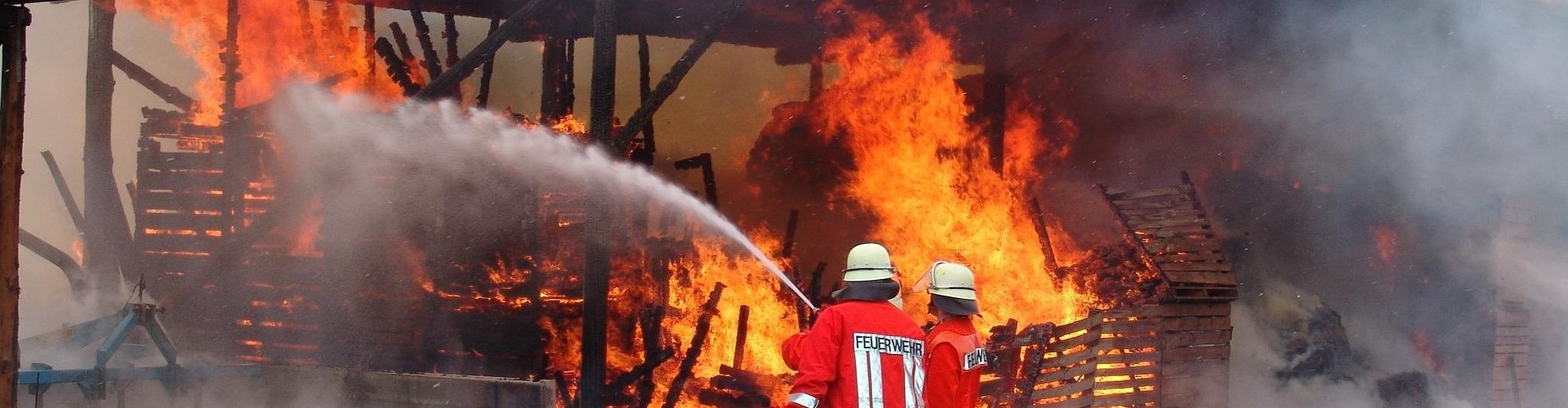 Feuer wird von 2 Feuerwehrleuten gelöscht