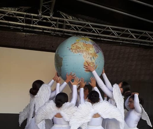 Viele Personen heben einen Globus in die Luft