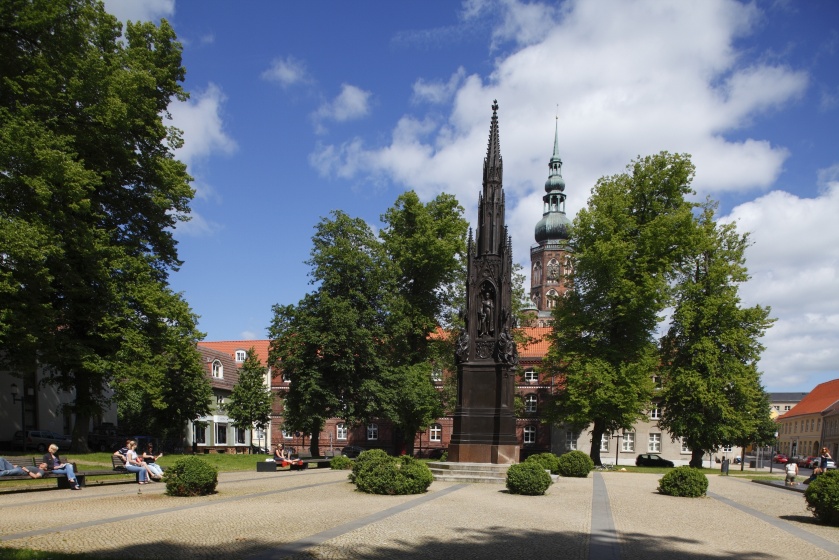 Blick vom Rubenowplatz mit dem Rubeneowdenkmal auf den Turm des Domes St. NikolaiSt - © Torsten Krüger Blick vom Rubenowplatz mit dem Rubeneowdenkmal auf den Turm des Domes St. NikolaiSt