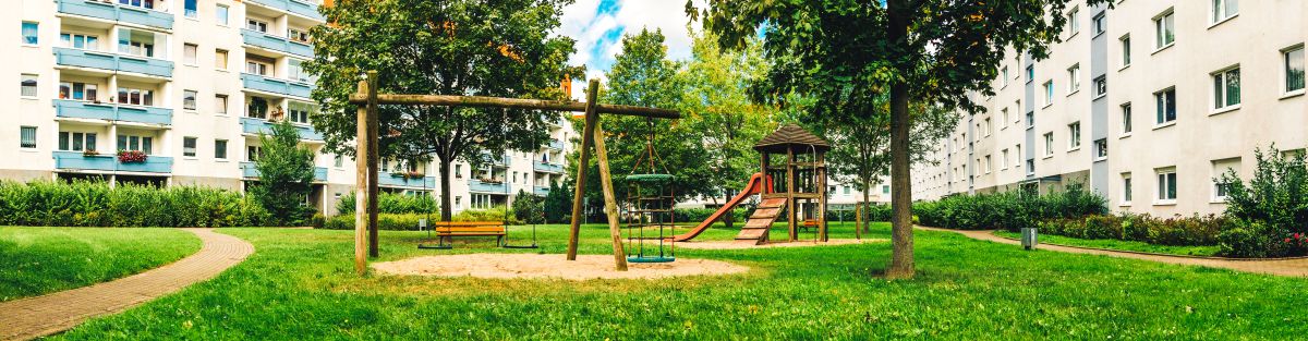 Spielplatz im Innenhof umgeben von Bäumen