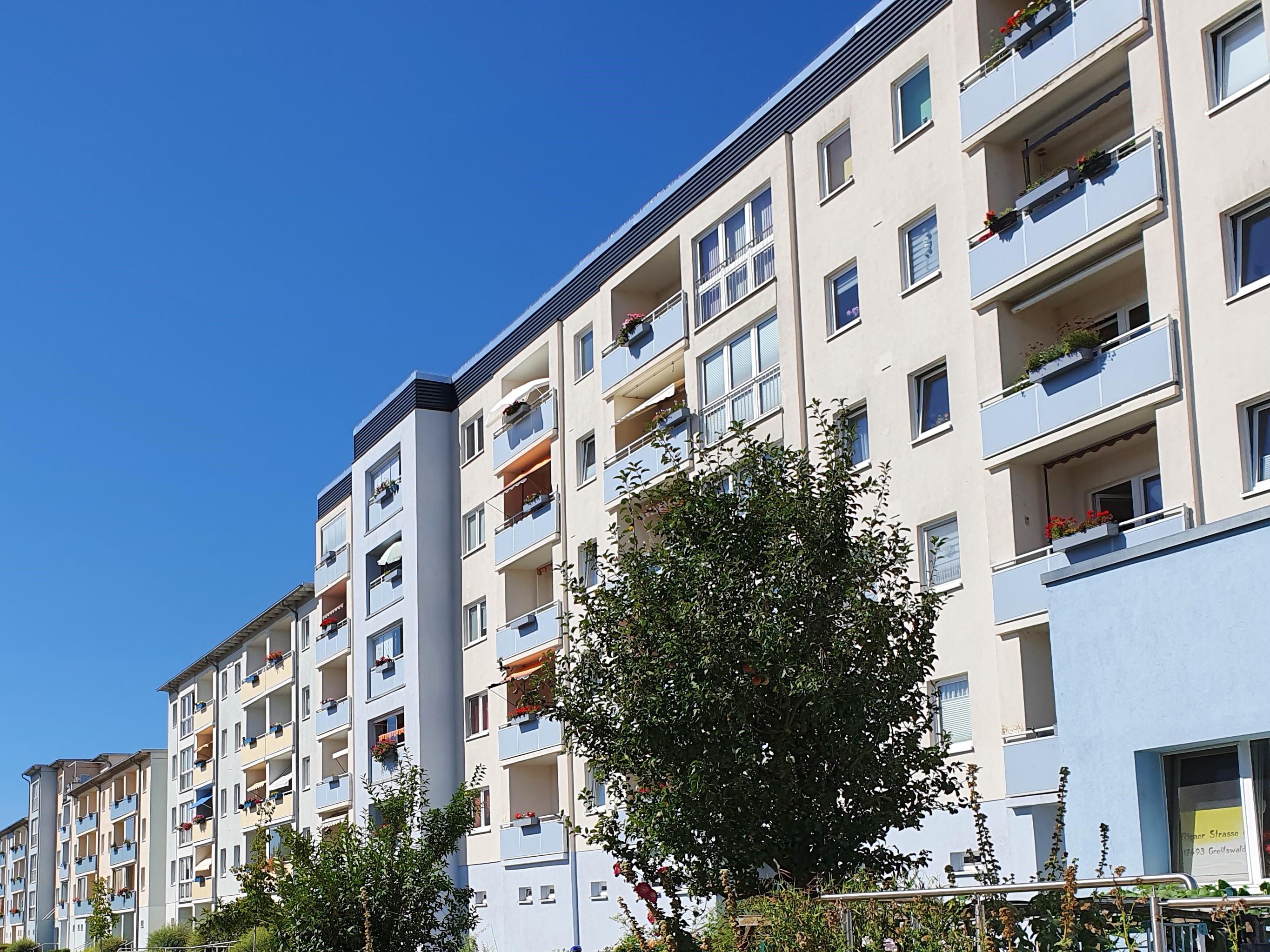 Eine blau-beige Häuserzeile mit vielen Balkonen