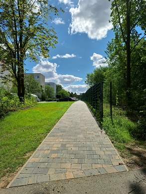 Neuer Gehweg im Puschkinring © Quartierskoordination der Universitäts- und Hansestadt Greifswald Ein Gehweg im Grünen, links einige Häuser, rechts ein Zaun