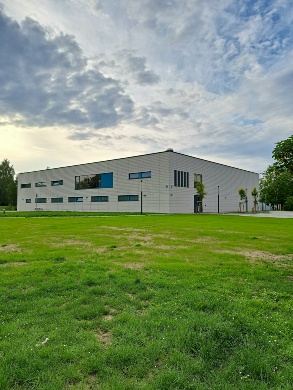 Sporthalle 2 © Quartierskoordination der Universitäts- und Hansestadt Greifswald Eine grüne Wiese und die Sporthalle 2