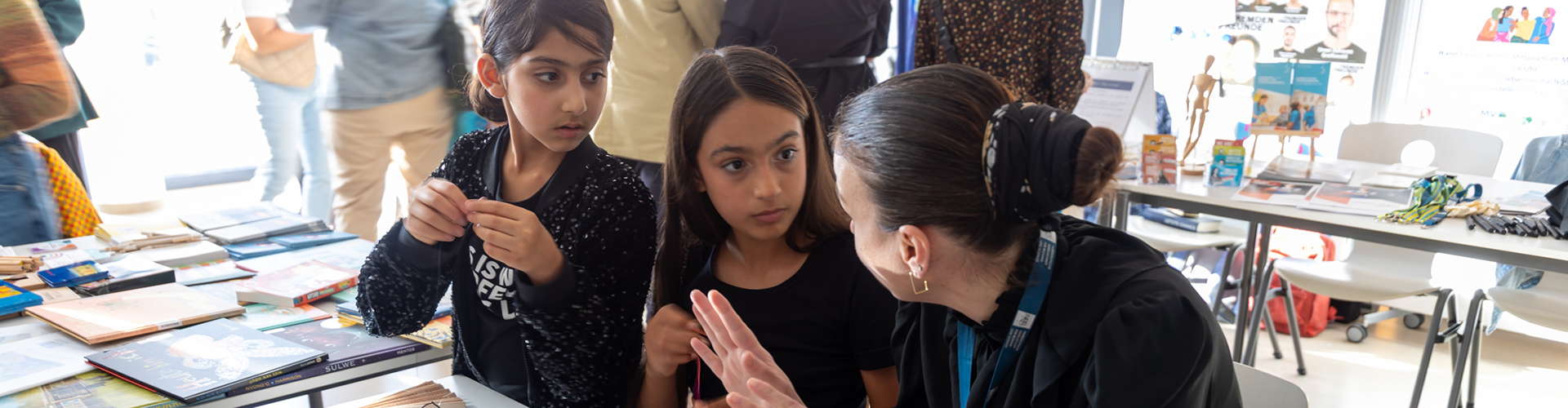 Zwei Mädchen unterhalten sich mit einer Frau