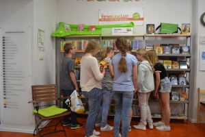Die Kinder lesen in der Stadtbibliothek in den neuen Romanen für die Ferienleselust
