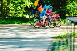 Fahrradfahrer mit zwei kleinen Radfahrern