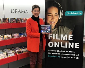 Leiterin Anja Mirasch vor einem Plakat mit dem neuen Streamingdienst