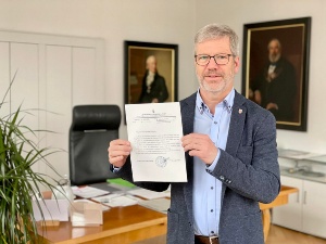 Oberbürgermeister Dr. Stefan Fassbinder steht in seinem Büro und hält das Dankesschreiben aus Drohobytsch