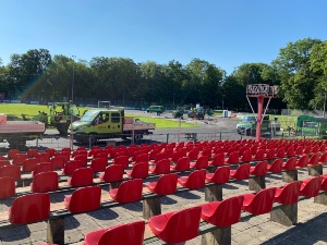 Blick von der Haupttribüne auf die Laufbahn, dort sind viele Baufahrzeuge