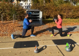 Zwei Aktive trainieren mit Medizinbällen  vor der Sportbox