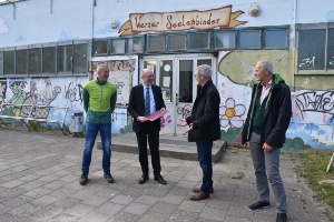 Minister Pegel übergibt vor der Sporthalle III Förderbescheide unter anderem an Dr. Fassbinder