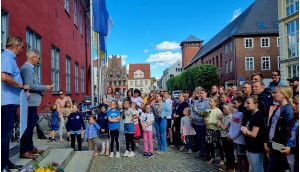 Dr. Fassbinder  und Thomas Prauße mit vielen Kindern und Erwachsenen vor dem Rathaus