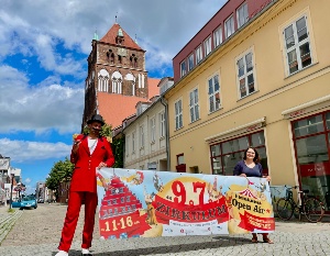 Innenstadtkoordinatorin Ramona Wolf und Mitorganisator Elias Elastisch halten das Banner zum ersten Greifswalder Zirkulum hoch