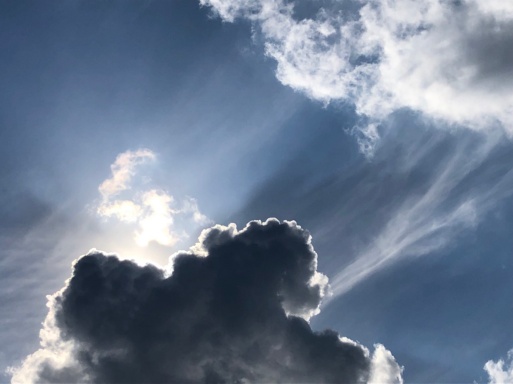 Die Sonne scheint durch weiße Wolken