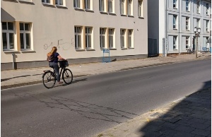 Fahrradfahrerin fährt an der zählstation im Boden vorbei