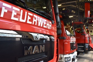 Mehrere Einsatzfahrzeuge der Feuerwehr Greifswald stehen aufgereiht in der Halle auf ihren Parkplätzen