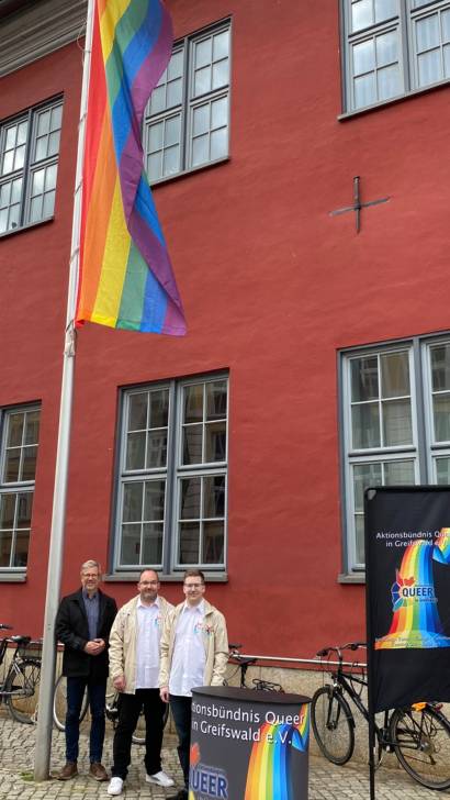 OB Dr Fassbinder Thomas Jager und Lukas Kretschmer von queer hissen die Regenbogenfahne am Rathaus Foto Pressestelle