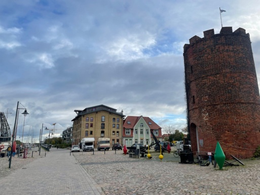 Platz vor dem Fangenturm im Museumshafen mit einzelnen Autos, die dort parken