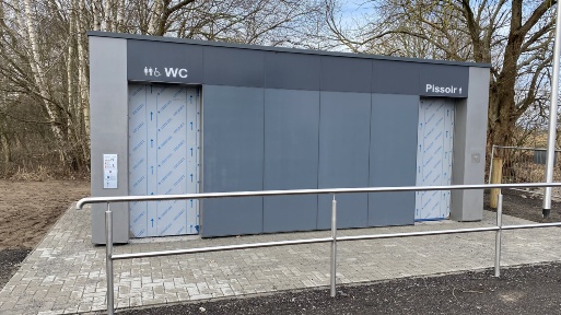 Blick auf das Gebäude der neuen öffentlichen Toilette auf dem Parkplatz hinter der Eldenaer Mühle