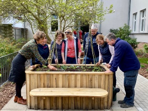 Die Unterstützer des Projektes bestaunen die neuen Hochbeete im Innenhof.