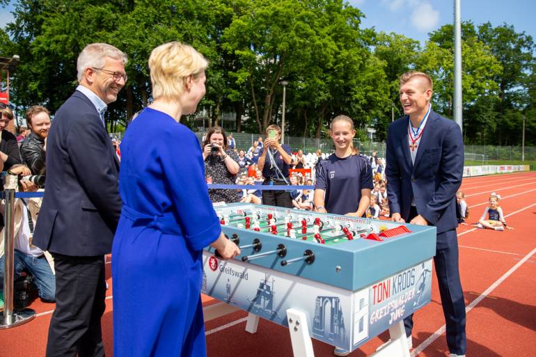Toni Kroos am Tischkicker-Unikat mit Ministerpräsidentin Manuela Schwesig Oberbürgermeister Dr. Stefan Fassbinder und Fußballkind Maja 