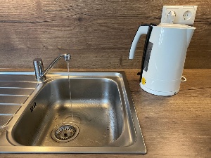 tropfender Wasserhahn und Wasserkocher in einer Küche
