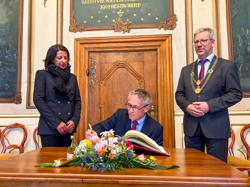 Dänemarks Botschafter Thomas Østrup Møller trägt sich ins Goldene Buch der Stadt ein, links Prof. Madeleine Tolani, rechts Oberbürgermeister Dr. Stefan Fassbinder