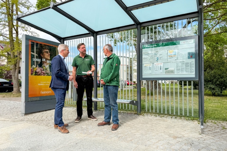 Dr. Stefan Fassbinder, Frank Tetzlaff und Dr. Andreas Kerath vor einem Buswartehäuschen mit Vogelanprallschutz