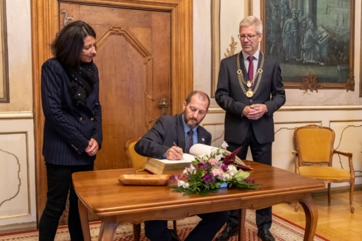 Generalkonsul Scoot Woodard (mi.) beim Eintrag ins Goldene Buch der Stadt, neben ihm Prof. Dr. Madeleine Tolani (li.) und Oberbürgermeister Dr. Stefan Fassbinder (re.)
