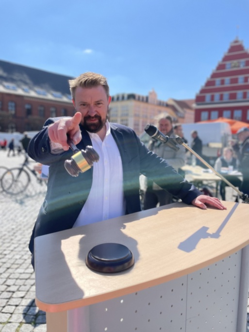 Auktionator Markus Müller bei der Fundradversteigerung zum Gartenmarkt 2023