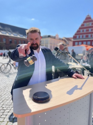 Auktionator Markus Müller bei der Fundradversteigerung zum Gartenmarkt 2023