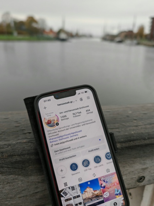 Foto eines Handys mit dem Instagram-Profil der Stadt Greifswald auf dem Display