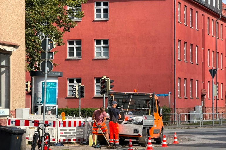 Kollegen des Tiefbau- und Grünflächenamtes bauen Verkehrszeichen für Schulwegsicherung an