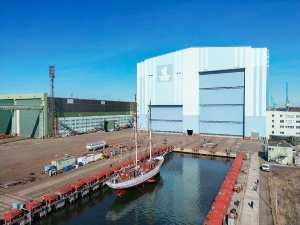 Luftaufnahme der SSS GREIF vor der blauen Werfthalle des Maritimen Industrie- und Gewerbeparks "Volkswerft" Stralsund