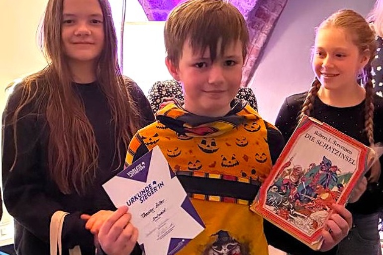 Theodor Killer Sieger des Regionalentscheids Greifswald im Vorlesewettbewerb des Deutschen Buchhandels in der Stadtbibliothek Hans Fallada, rechts Helena Donath von der Regionalen Schule Caspar David Friedrich und links Emilia Fenzke von der Ernst-Moritz-Arndt-Schule