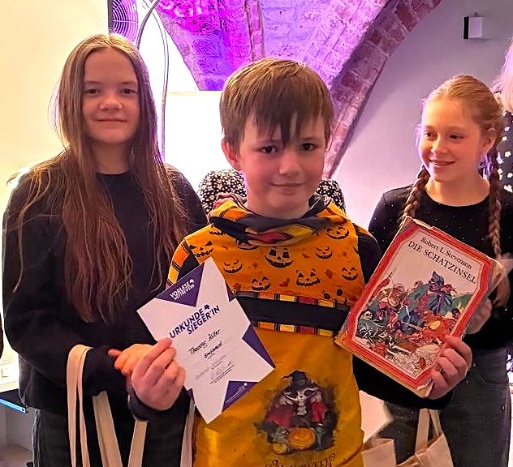 Theodor Killer Sieger des Regionalentscheids Greifswald im Vorlesewettbewerb des Deutschen Buchhandels in der Stadtbibliothek Hans Fallada, rechts Helena Donath von der Regionalen Schule Caspar David Friedrich und links Emilia Fenzke von der Ernst-Moritz-Arndt-Schule